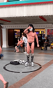 The scantily-clad performer with face paint has covered his face with one hand, to let me know that it's not okay to take pictures for free! Donations encouraged!