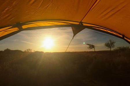 Taken from inside of the tent, this photo shows the sun rising through the open door.