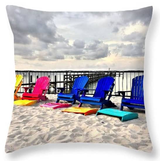 An image of a square pillow displaying an image of white sand under some colorful Adirondack chairs, under How to make your own throw pillows.