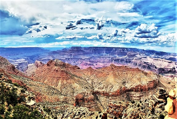 Taken from the upper level of the watchtower, this photo shows the peaks and valleys within the overall immense ("GRAND") canyon. The photo is split in the middle: Sky above, Canyon below.