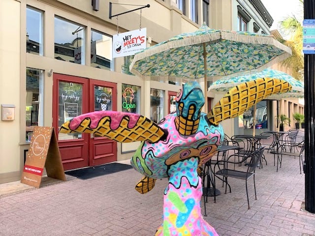 This curbside flying turtle matches the theme of the waffle-cone shop behind it! Pinks and mint greens, and turquoise blues on waffle fins/wings. Okay - so they're swimming turtles - not flying ones - but they're propped up at an angle like they're flying.