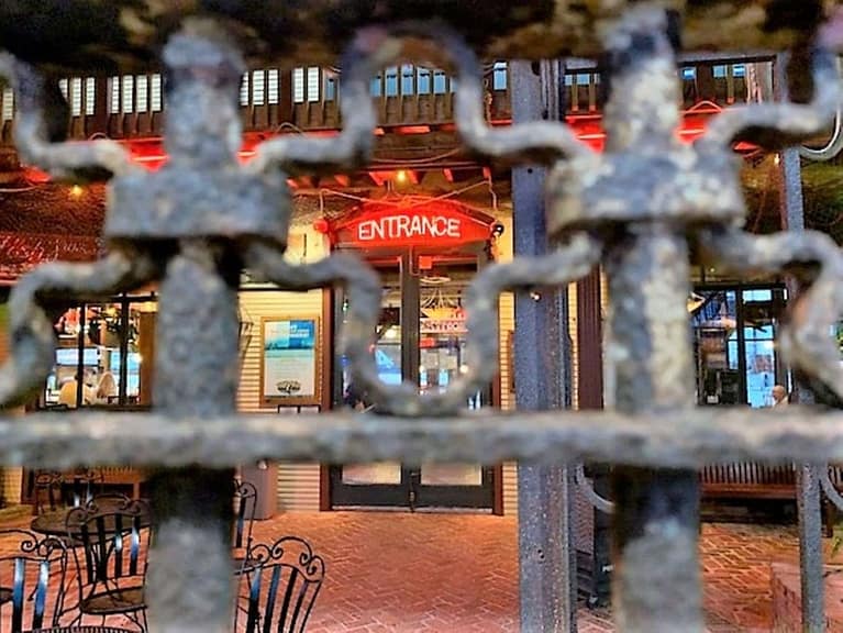 The image reads "entrance". The photo is taken through an iron railing.
