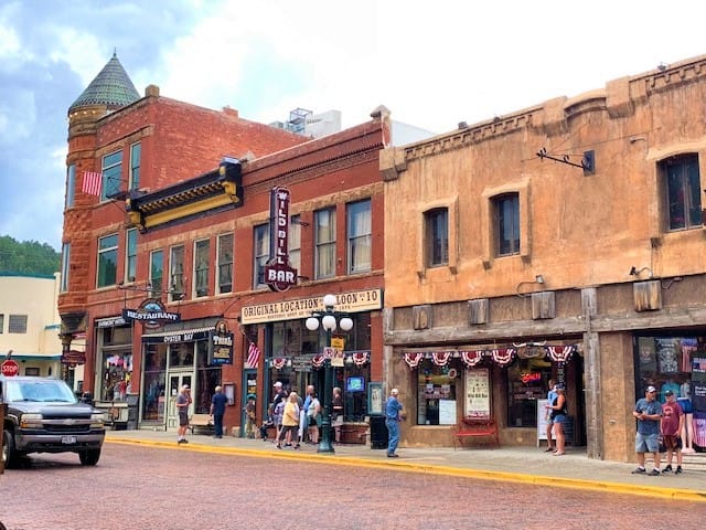 The main street in Deadwood shows brick two-story buildings with stores below (and presumably living quarters above)