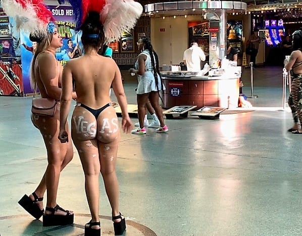 Two gals in thongs (and breast paint) stand in their circle on the Fremont Street Mall.